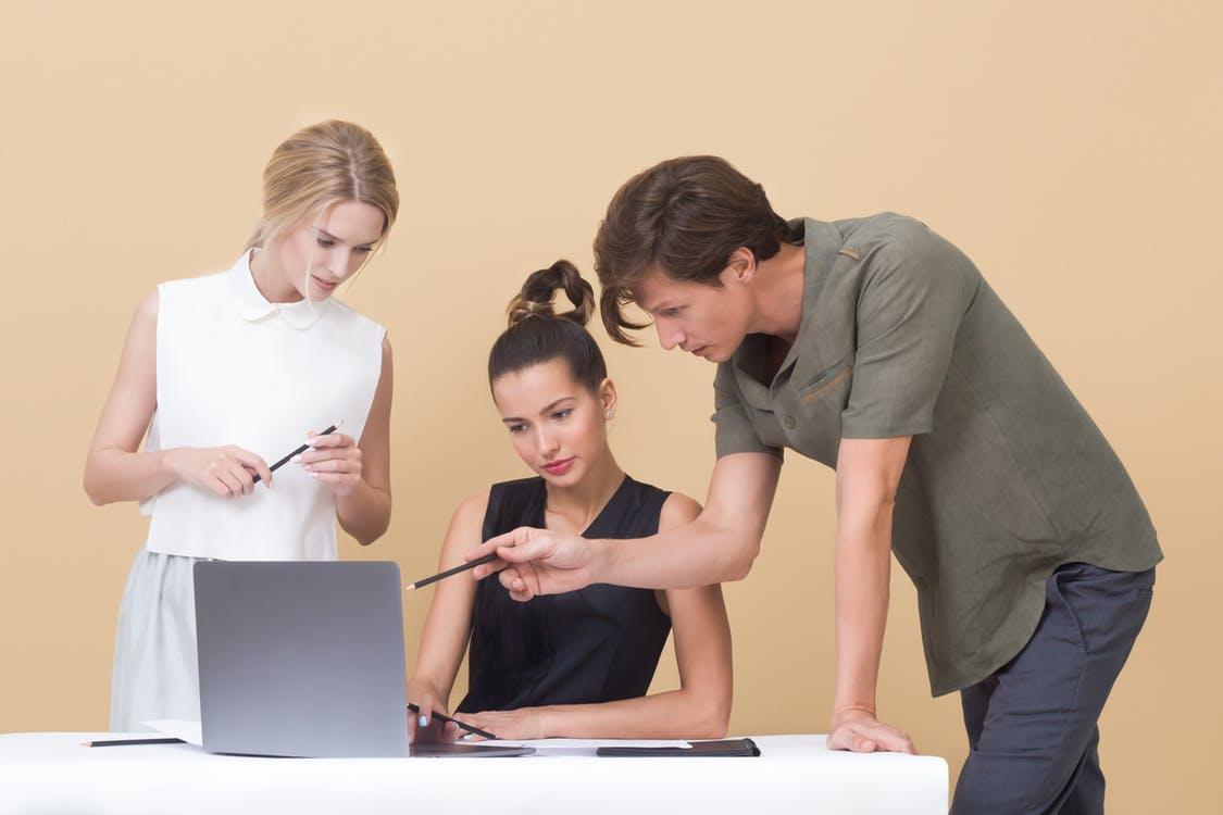 Three Colleagues Discussing Over a Laptop