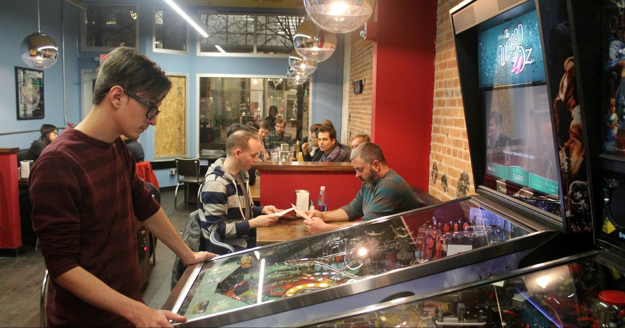 Boy Playing an Arcade Game in a Restaurant